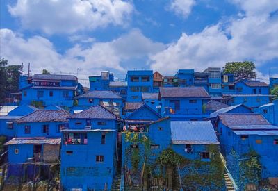 Buildings in city against cloudy sky