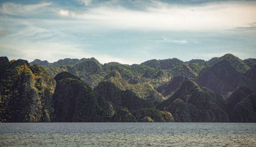 Scenic view of sea and mountains against sky