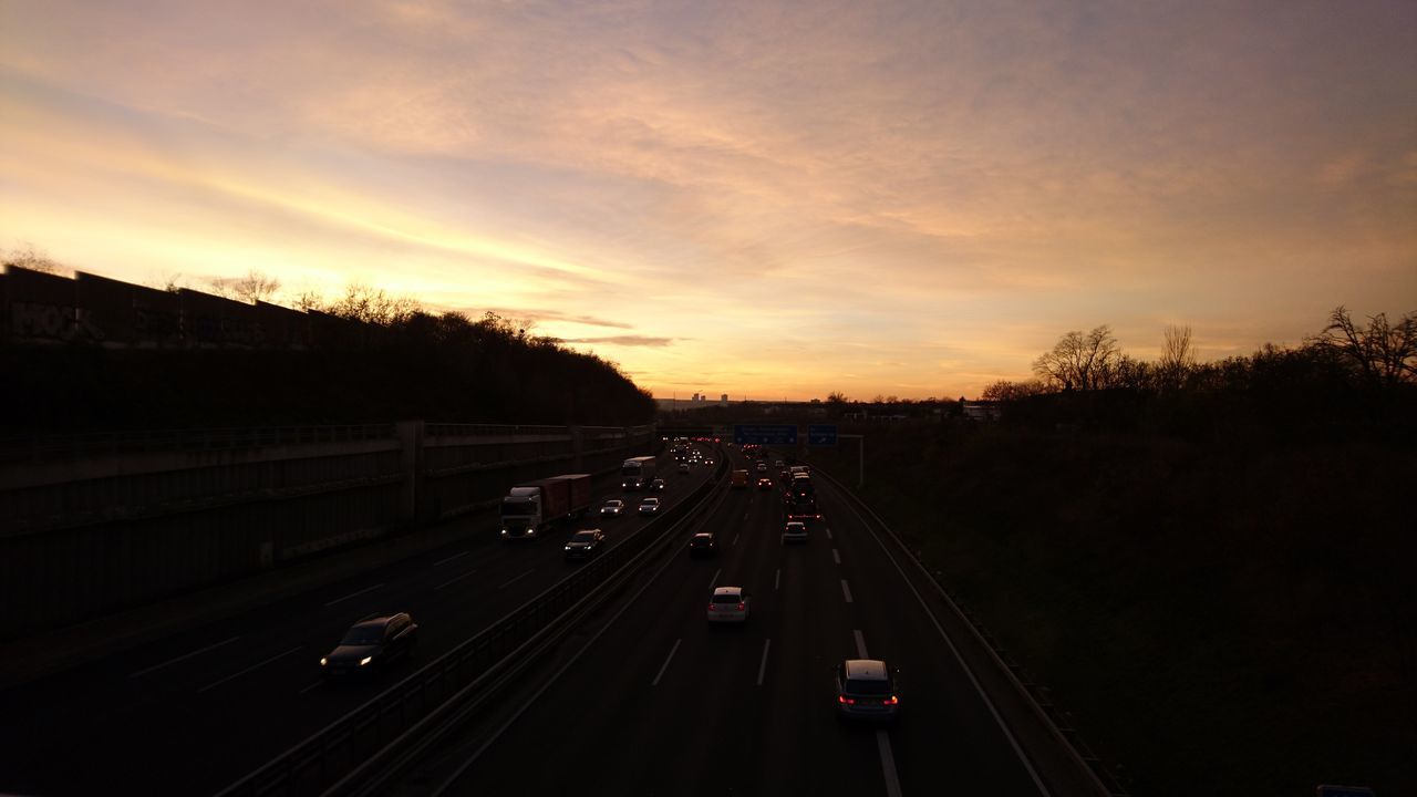 HIGH ANGLE VIEW OF CARS ON ROAD AGAINST SKY