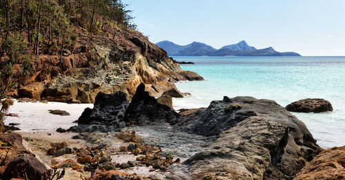 Scenic view of rocks in sea against sky