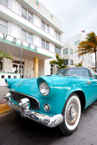 Vintage car on street by buildings