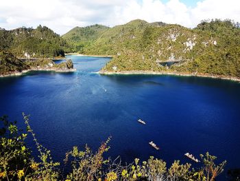 High angle view of lake and trees against blue sky