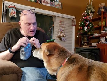 Portrait of man with dog sitting at home