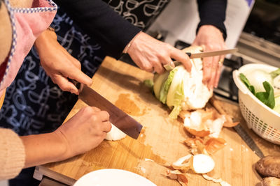 Midsection of man preparing food on cutting board