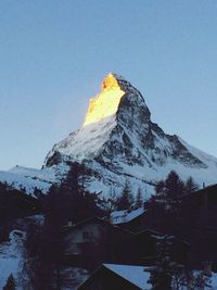 Scenic view of snow covered mountains against clear blue sky