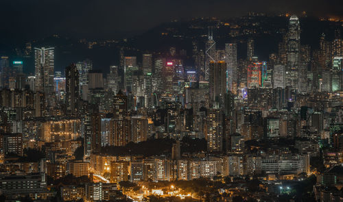 Illuminated cityscape against sky at night