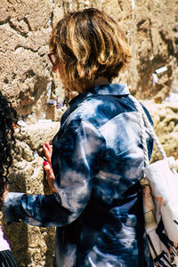 Rear view of people standing on rock