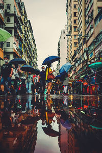 People on street in city during rainy season