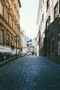 Cobblestone street amidst buildings in city