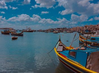 Sailboats moored on sea against sky