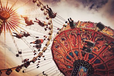 Low angle view of people enjoying chain swing ride