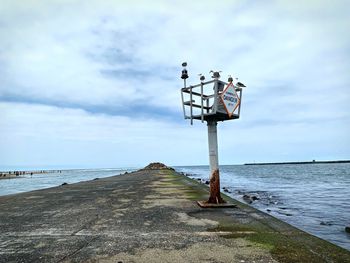 Lifeguard hut on beach against sky