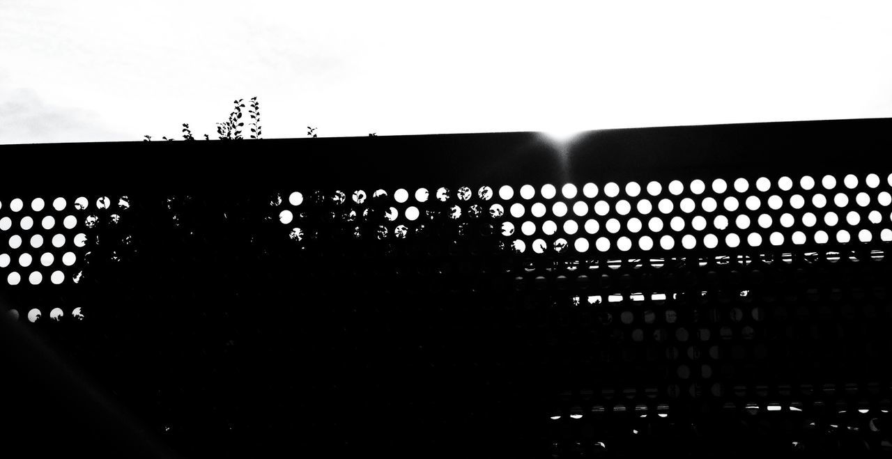 clear sky, silhouette, built structure, architecture, fence, building exterior, sky, copy space, low angle view, sunset, no people, outdoors, metal, sunlight, protection, house, nature, street light, safety, dusk