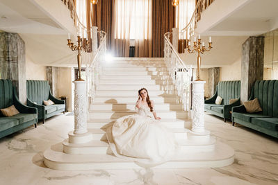 Woman sitting on staircase in building