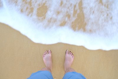 Low section of woman standing on beach