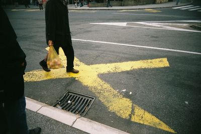 Low section of people walking on road