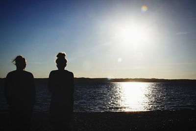 Silhouette man standing by sea against clear sky during sunset