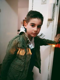 Portrait of boy wearing jacket while standing at home