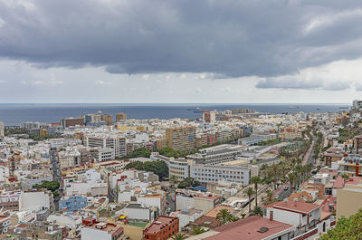 High angle view of townscape by sea against sky