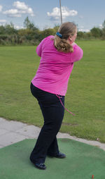 Full length of mature woman standing on golf course