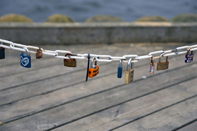 Close-up of padlocks hanging on railing over bridge