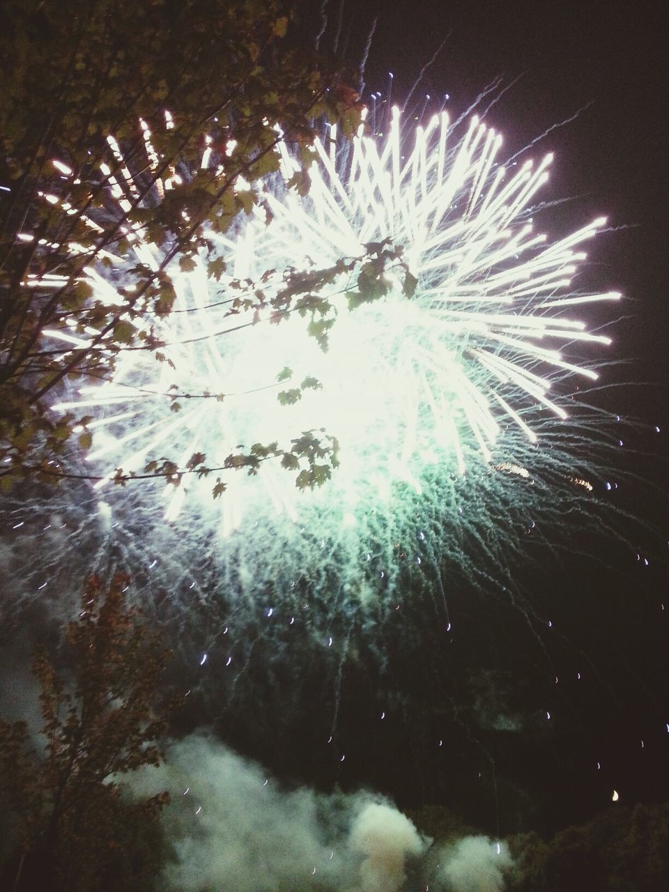 night, long exposure, firework display, motion, illuminated, water, celebration, exploding, arts culture and entertainment, sparks, glowing, blurred motion, sky, low angle view, firework - man made object, reflection, firework, outdoors, smoke - physical structure, entertainment