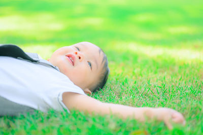 Portrait of man lying on grassy field