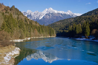 Scenic view of lake against mountains during winter