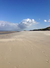 Scenic view of beach against blue sky