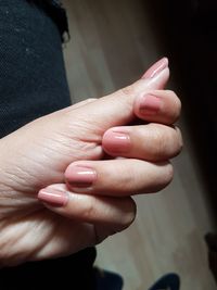 Cropped hand of woman with pink nail polish