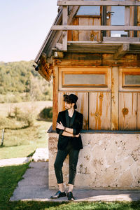 Full length portrait of young man standing against building