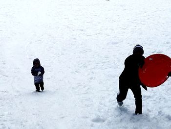 Rear view of two people in snow