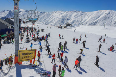 Cable car, skiers and snowboarders on the track at the ski resort