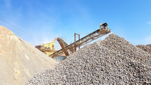 Low angle view of crane against blue sky