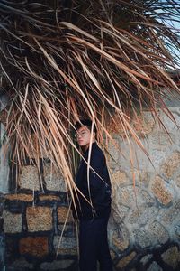 Portrait of young man standing against wall