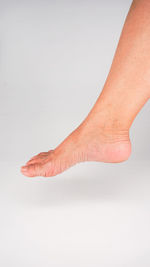 Low section of woman against white background
