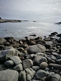 Rocks on beach against sky