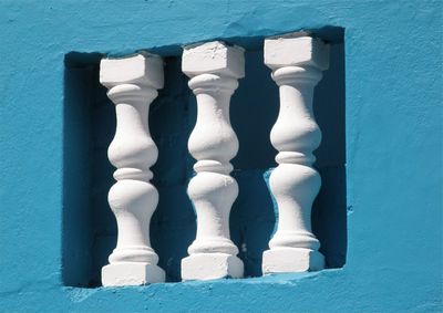 Close-up of white balustrade on blue wall