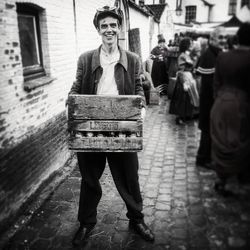 Portrait of smiling steampunk carrying crate