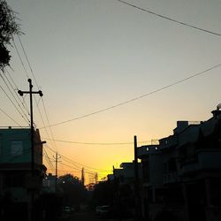 Silhouette electricity pylon against sky during sunset