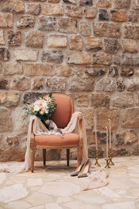 Potted plant on chair against wall