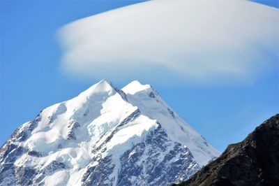 Scenic view of snowcapped mountains against blue sky