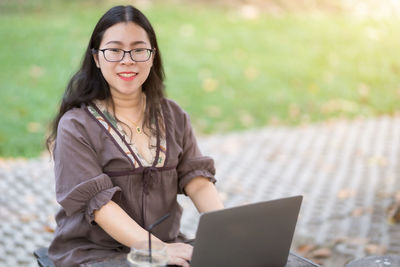 Portrait of young woman using mobile phone outdoors