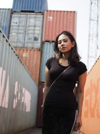 Beautiful young woman standing against wall