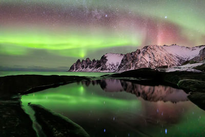 Scenic view of lake against dramatic sky at night