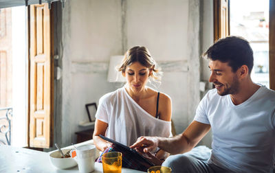 Young man and woman sitting on table