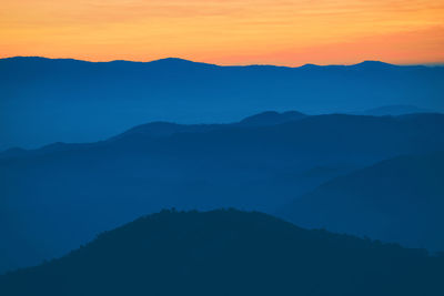 Scenic view of silhouette mountains against sky during sunset