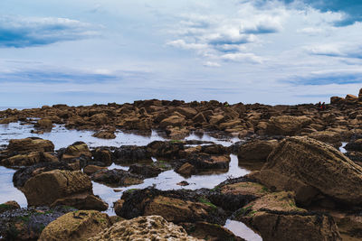 Rocks on beach against sky