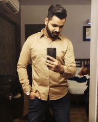 Full length of young man using mobile phone