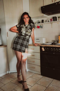 Young woman standing against wall
